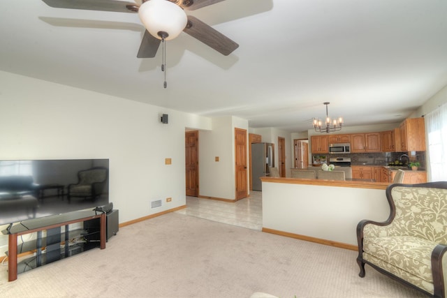 kitchen with tasteful backsplash, stainless steel appliances, decorative light fixtures, light colored carpet, and kitchen peninsula