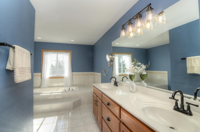 bathroom with tiled bath, tile patterned floors, vanity, and a wealth of natural light