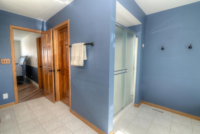 bathroom featuring an enclosed shower and tile patterned flooring