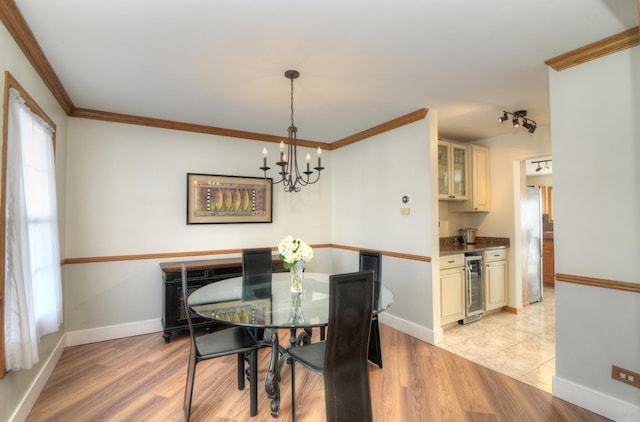 dining area featuring a chandelier, wine cooler, light hardwood / wood-style floors, and crown molding