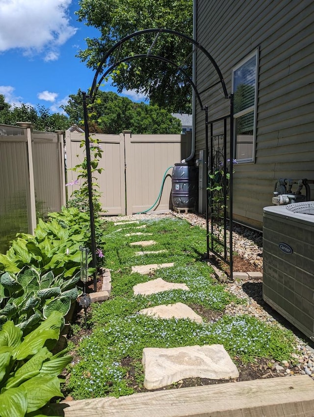 view of yard featuring fence and central air condition unit