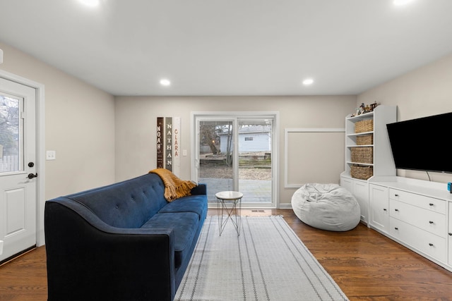 living area with dark wood-style floors and recessed lighting