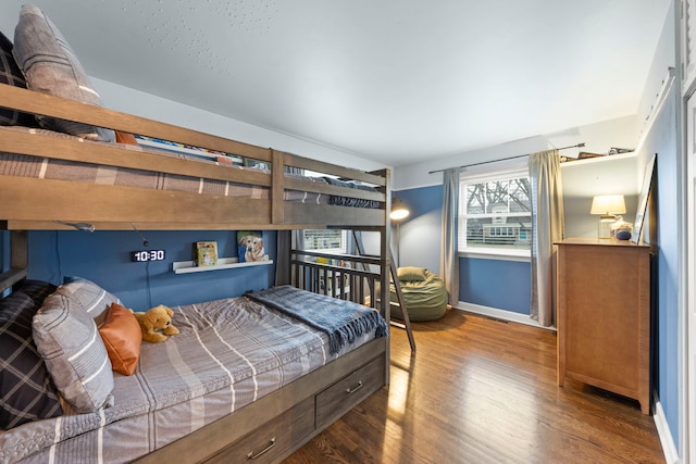 bedroom with baseboards and wood finished floors