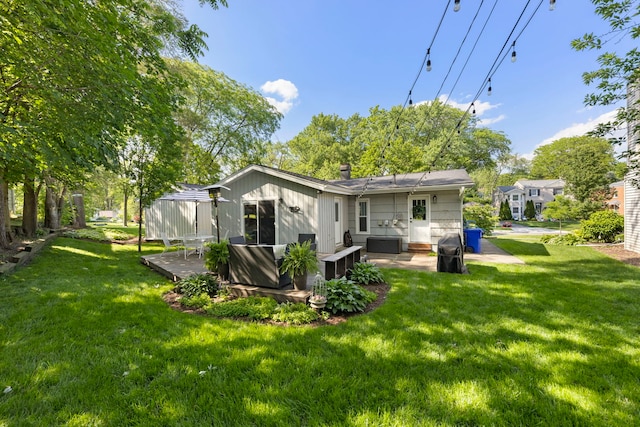 back of house featuring a lawn and a deck