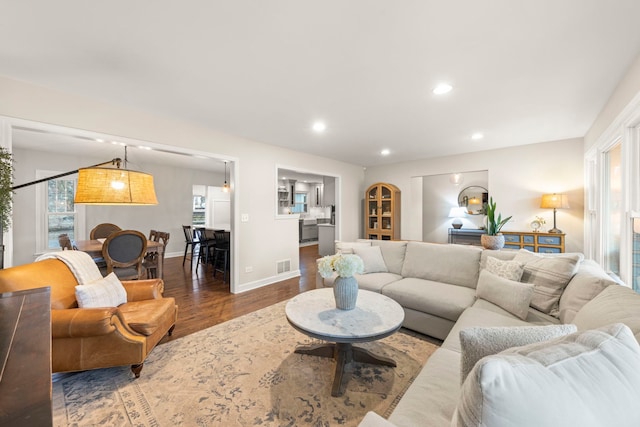 living area featuring a wealth of natural light, recessed lighting, visible vents, and wood finished floors