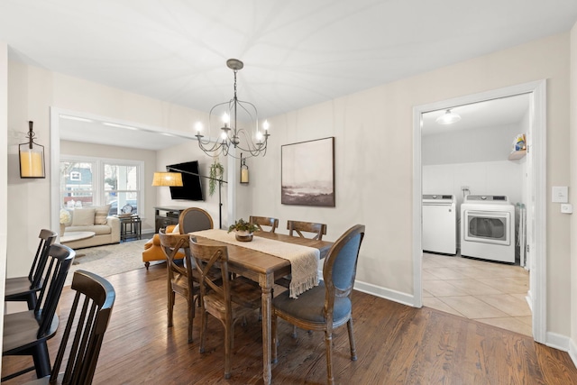 dining space with a chandelier, separate washer and dryer, wood finished floors, and baseboards