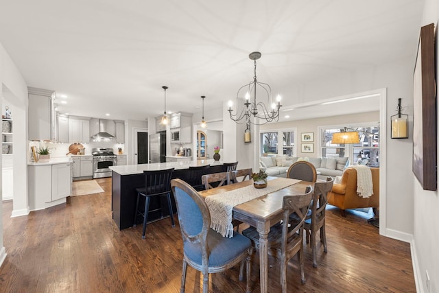 dining area with dark wood-style floors, a chandelier, and baseboards