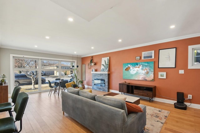 living room with a fireplace, light hardwood / wood-style flooring, and ornamental molding