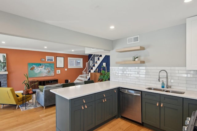 kitchen with sink, backsplash, light hardwood / wood-style floors, stainless steel dishwasher, and kitchen peninsula