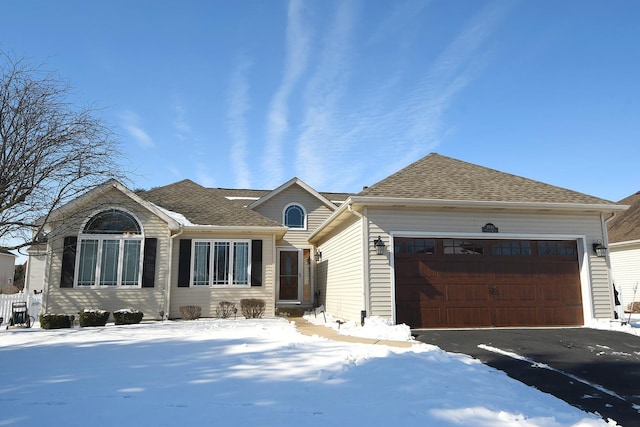 ranch-style house with roof with shingles, driveway, and an attached garage