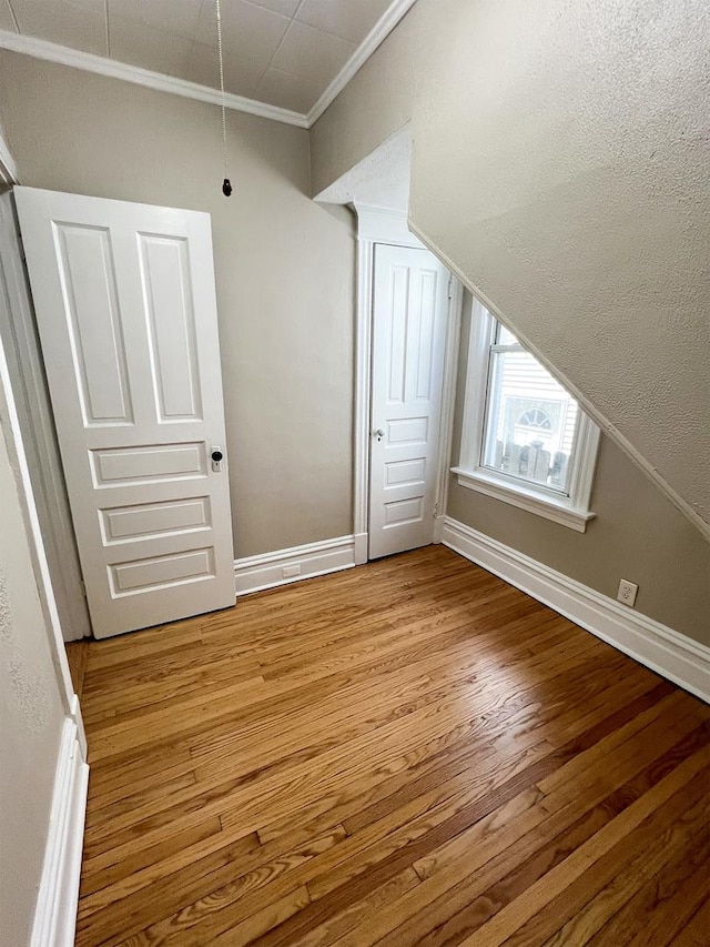 additional living space with light wood finished floors and baseboards