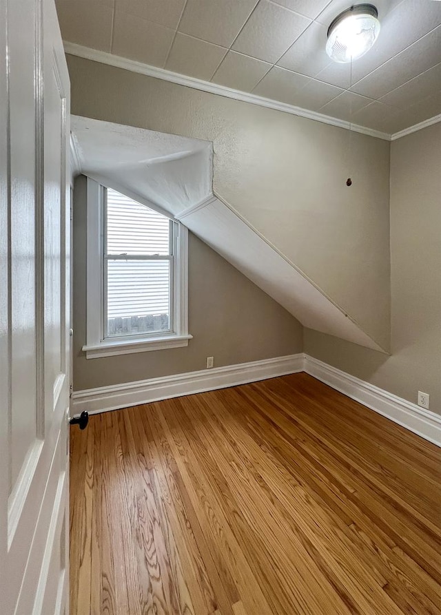 bonus room featuring lofted ceiling, wood finished floors, and baseboards