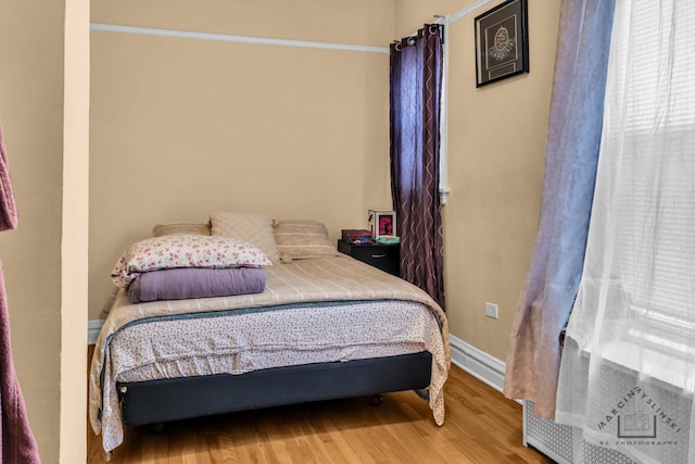 bedroom featuring light wood finished floors and baseboards