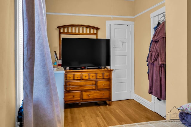 bedroom featuring light wood-style floors and baseboards