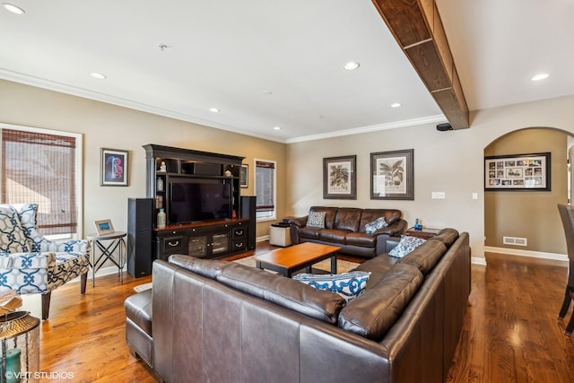 living room with arched walkways, recessed lighting, wood finished floors, baseboards, and beamed ceiling