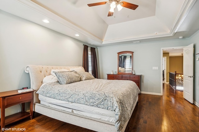 bedroom with dark wood finished floors, recessed lighting, a raised ceiling, ceiling fan, and baseboards