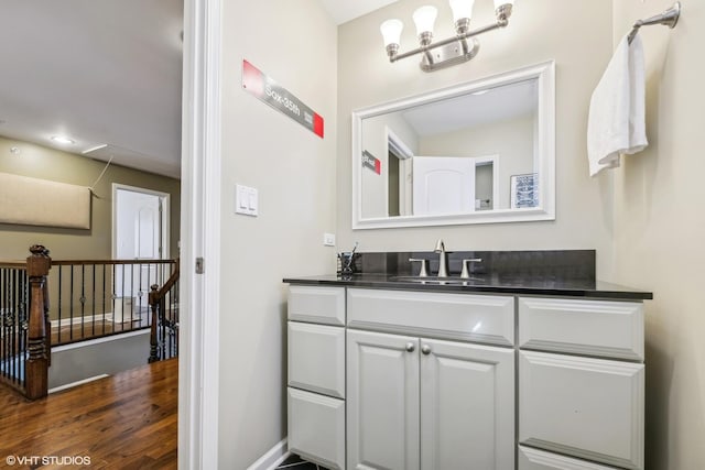 bathroom featuring vanity, baseboards, and wood finished floors