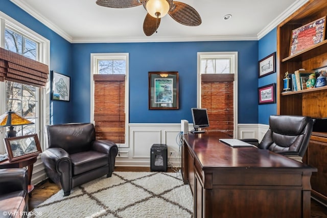 office space with a wainscoted wall, ceiling fan, crown molding, and wood finished floors