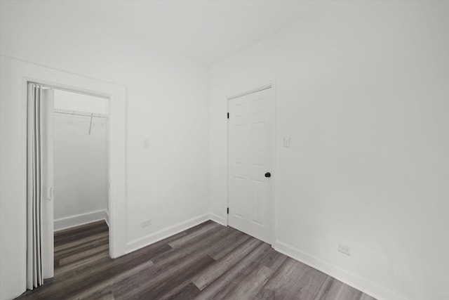 unfurnished bedroom featuring dark wood-type flooring and a closet