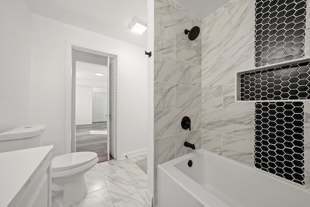 full bathroom featuring vanity, tiled shower / bath, and toilet