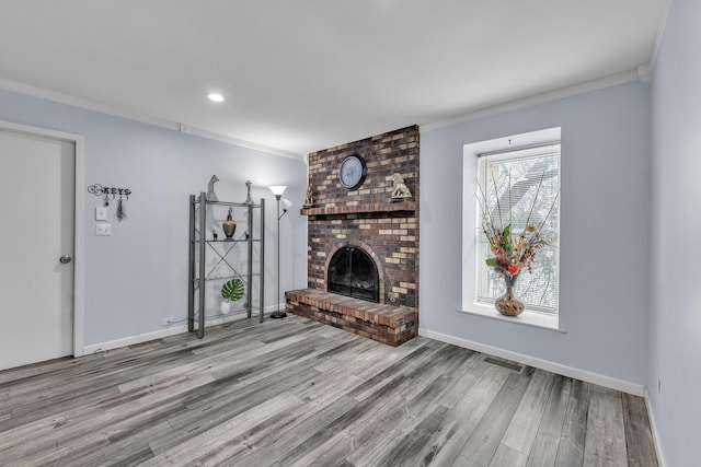 unfurnished living room featuring ornamental molding, a brick fireplace, light wood-style flooring, and baseboards