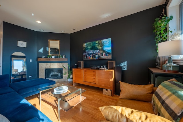 living area featuring recessed lighting, visible vents, wood finished floors, and a tile fireplace