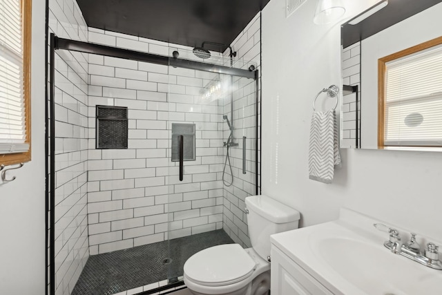 bathroom featuring vanity, an enclosed shower, and toilet