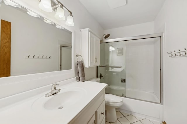 full bathroom with combined bath / shower with glass door, vanity, toilet, and tile patterned floors