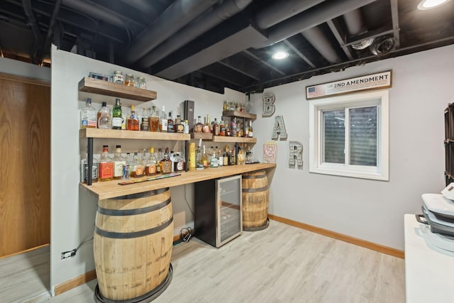 bar with wine cooler, wooden counters, and light wood-type flooring