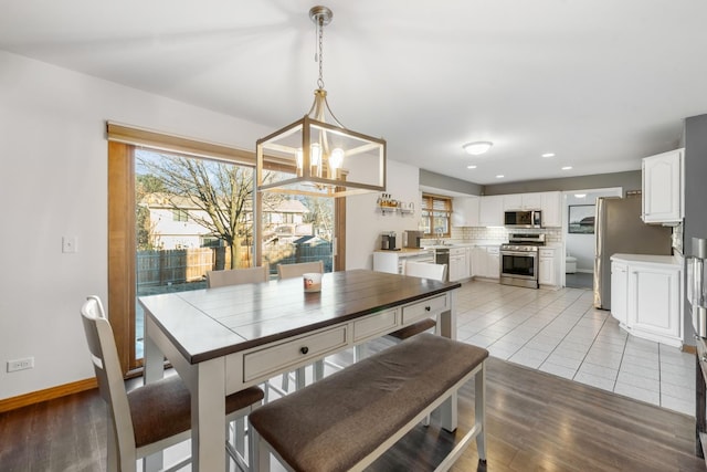 dining area with sink, a chandelier, and light hardwood / wood-style flooring