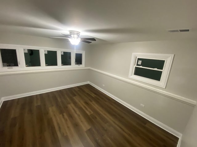 empty room with dark hardwood / wood-style floors and ceiling fan