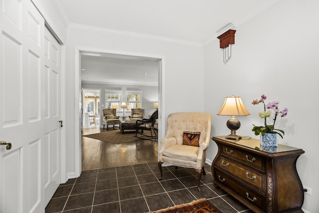 living area featuring dark tile patterned flooring and ornamental molding