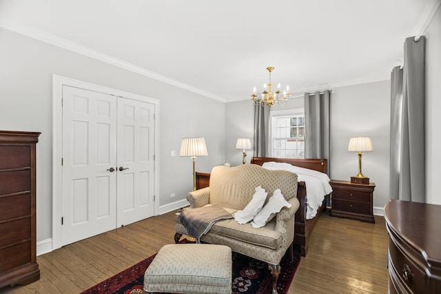 bedroom featuring a chandelier, crown molding, a closet, and dark hardwood / wood-style floors