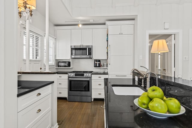 kitchen with sink, dark hardwood / wood-style floors, white cabinets, and stainless steel appliances