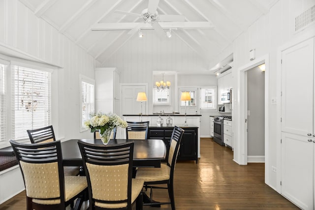 dining area with high vaulted ceiling, dark hardwood / wood-style floors, and a notable chandelier