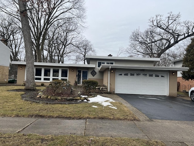 view of front of house featuring driveway, an attached garage, and brick siding