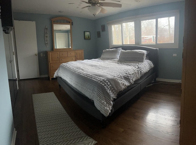 bedroom featuring dark wood-style floors, baseboards, and a ceiling fan