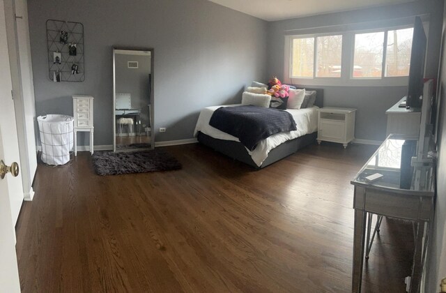 bedroom featuring dark wood-style floors, visible vents, ceiling fan, and baseboards