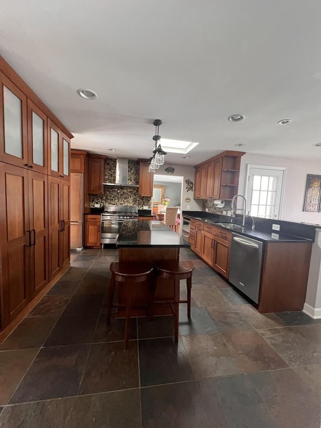 kitchen featuring dark countertops, a breakfast bar area, stainless steel appliances, open shelves, and a sink