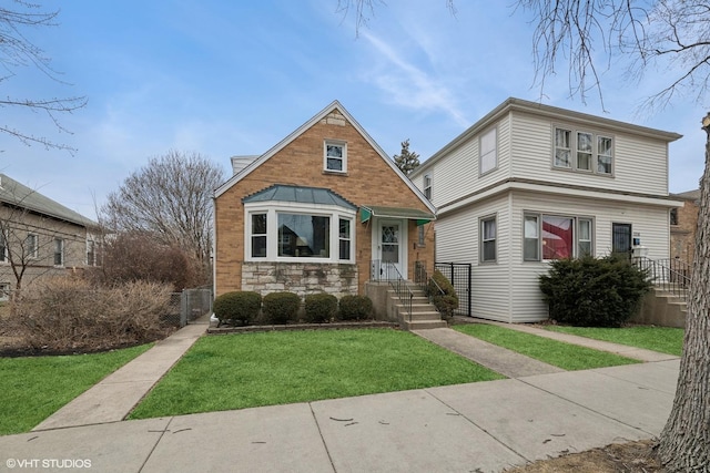 view of front facade with stone siding, fence, and a front yard