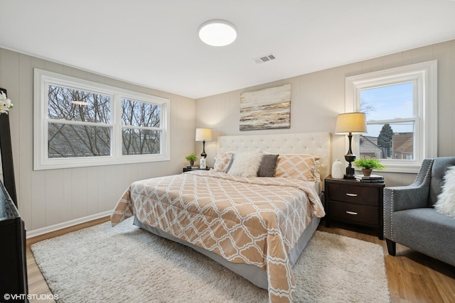 bedroom featuring wood finished floors, visible vents, and baseboards