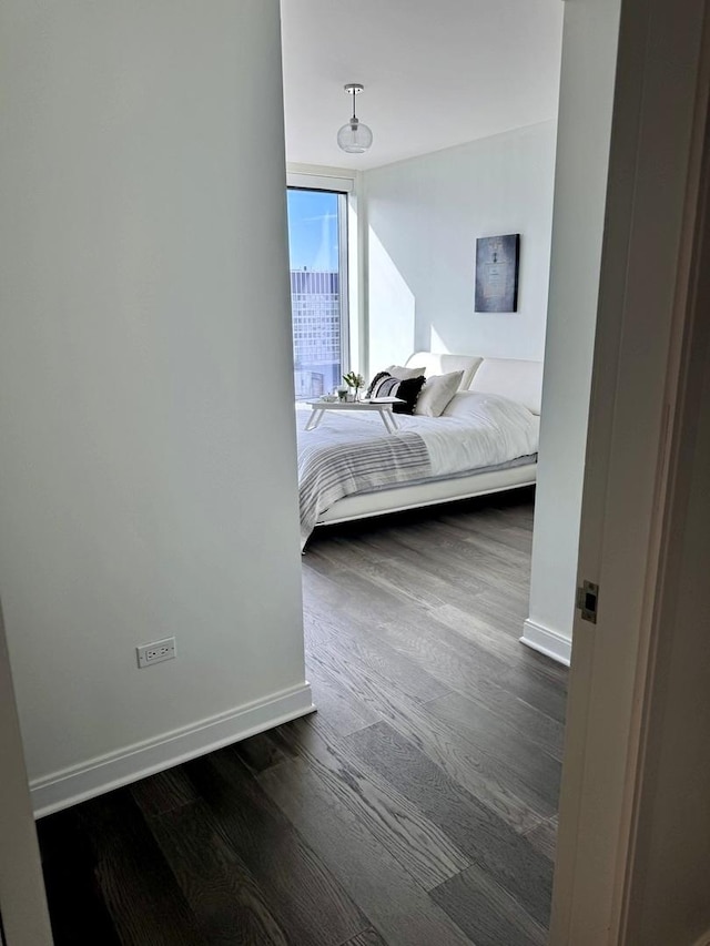 bedroom featuring dark wood-style flooring and baseboards