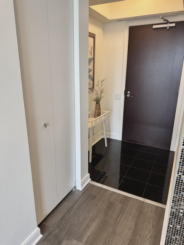 foyer featuring baseboards and wood finished floors