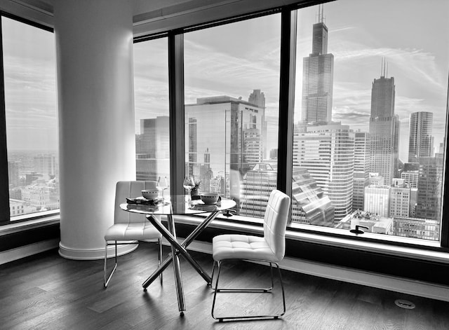 dining area featuring a view of city, wood finished floors, and baseboards