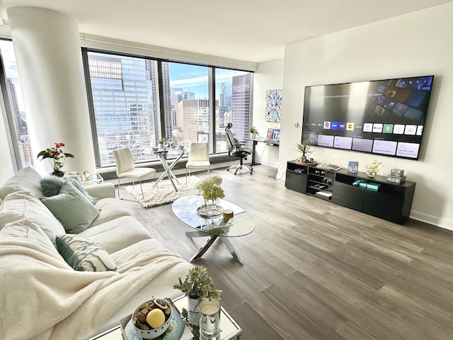 living area with expansive windows, wood finished floors, and baseboards