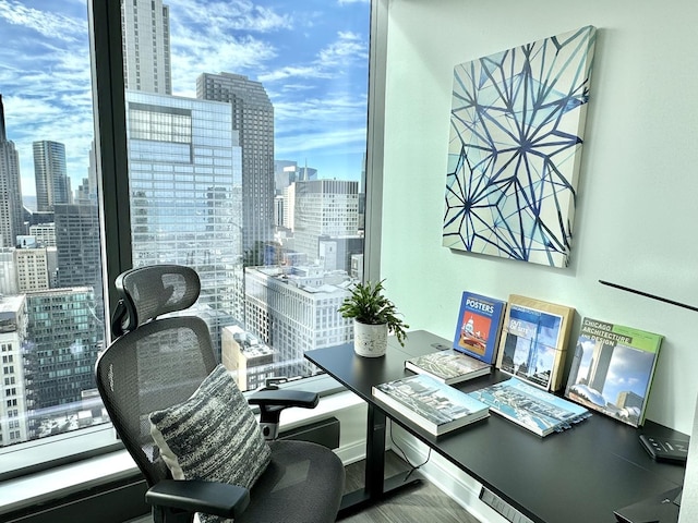 home office featuring a view of city, baseboards, and wood finished floors