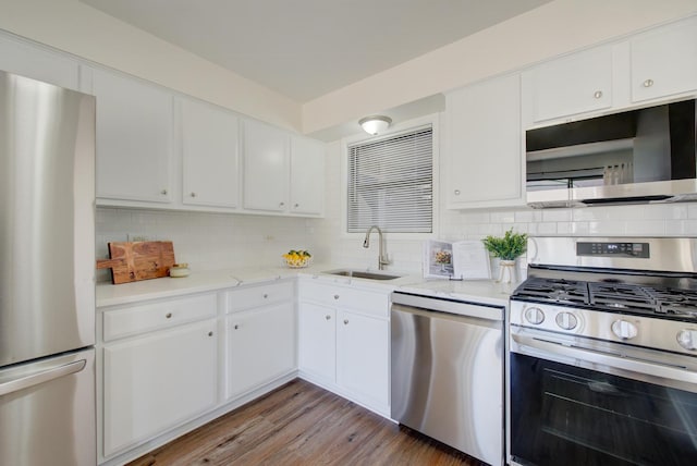 kitchen with stainless steel appliances, a sink, white cabinetry, and decorative backsplash