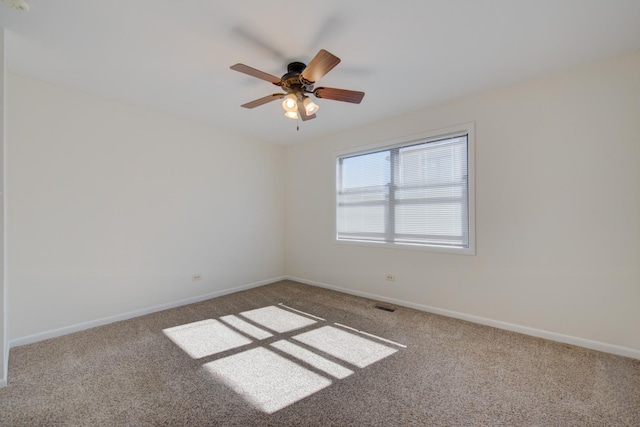 spare room with carpet, visible vents, ceiling fan, and baseboards