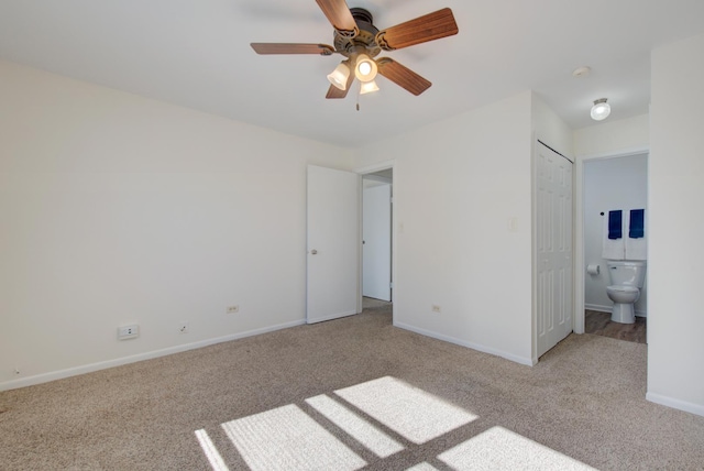 unfurnished bedroom featuring ensuite bathroom, ceiling fan, carpet flooring, and baseboards