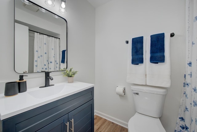 bathroom with visible vents, baseboards, toilet, wood finished floors, and vanity